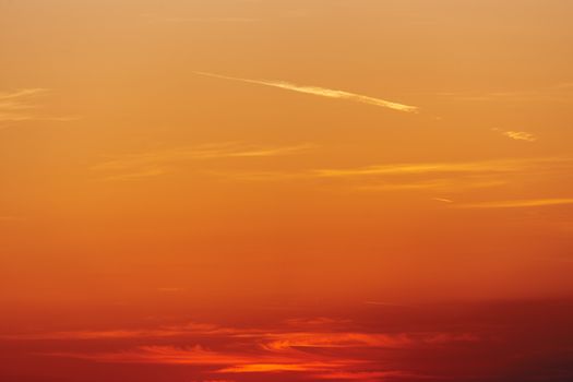 Colorful red sunset sky with plane traces