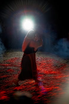 Bulgarian traditional Nestinari firedancer, a woman with icon in the hands dancing on live coals