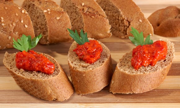Red pepper ajvar puree on bread slices