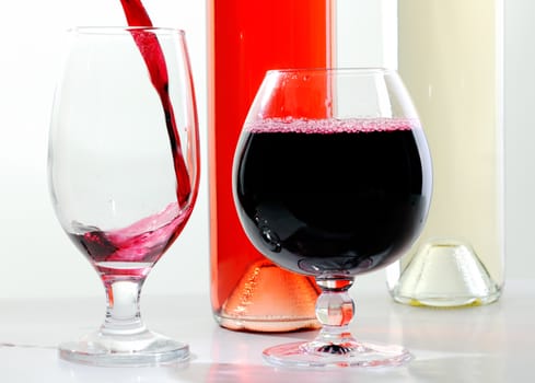 Glasses filled with red wine and bottles of wine