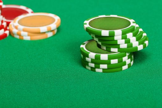 pile of playing chips on the green table