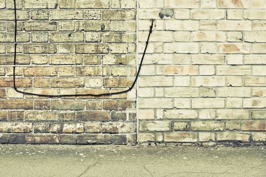 Telephone wire in a brick wall in muted tones