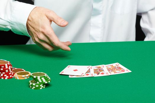 gambler. Male hand with cards and chips on green table