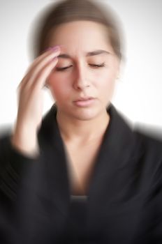 Business woman suffering from an headache, holding her hand to the head, with radial blur effect applied