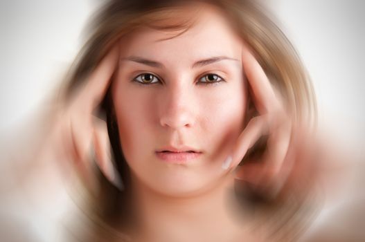 Woman suffering from an headache, holding her hands to the head, with radial blur effect applied