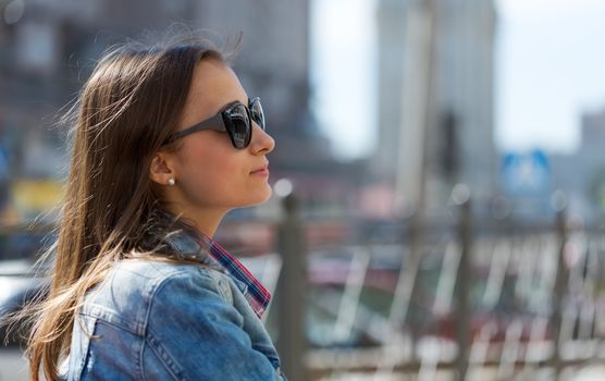 Portrait in profile of a beautiful young girl in sunglasses