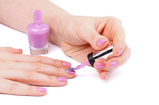 Woman's Hands Painting Purple Nail Polish isolated on white background