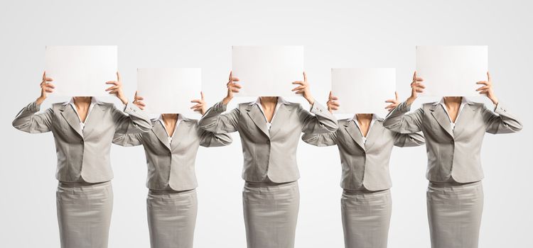 image of a businesswomen standing in a row, held in front of a blank poster