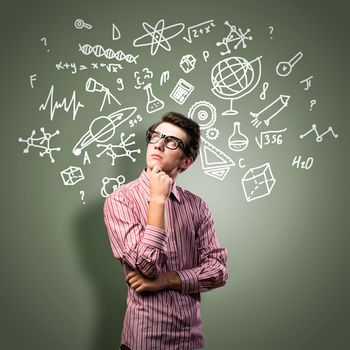 young man scientist in glasses thinking. next to it various painted symbols