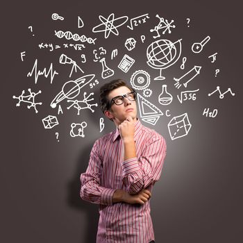 young man scientist in glasses thinking. next to it various painted symbols