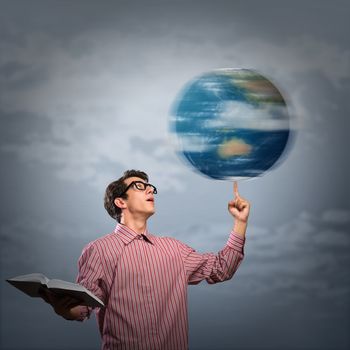 young man with a book thinks. keeps the finger symbol of the planet Earth. NASA images used