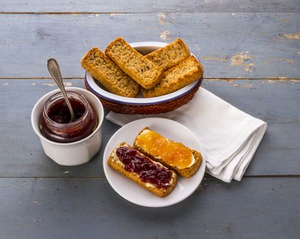 Still life with some toasts with jam and a white napkin, on an old blue table