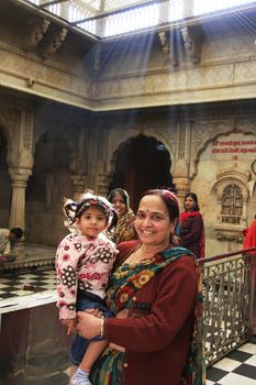 Indian woman with a girl standing inside of Karni Mata Temple, Deshnok, Rajasthan, India