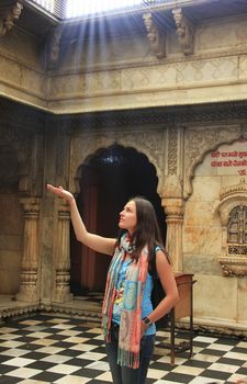 Young woman catching sun rays at Karni Mata Temple, Deshnok, Rajasthan, India