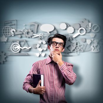 young man scientist in glasses thinking. next to it various painted symbols