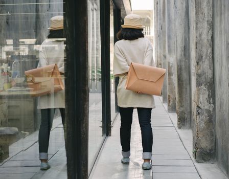 Young fashion girl with handbag at alleyway