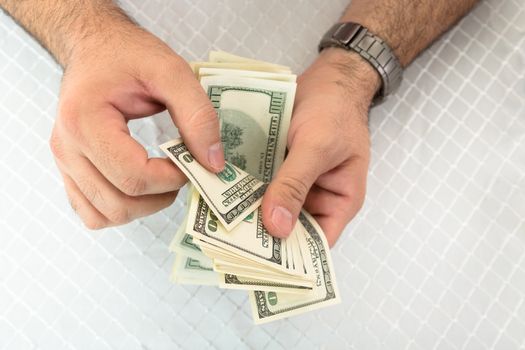 Close-up of a man hands counting dollar notes