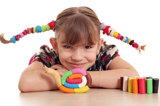 little girl make snail with plasticine