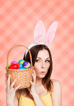 Excited girl holding bunch of painted eggs on pink background