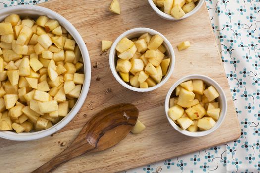 Chopped apples with sugar and spices in baking dishes.