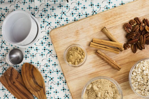 Cinnamon sticks , pecans and other spices on cutting board viewed from directly above.