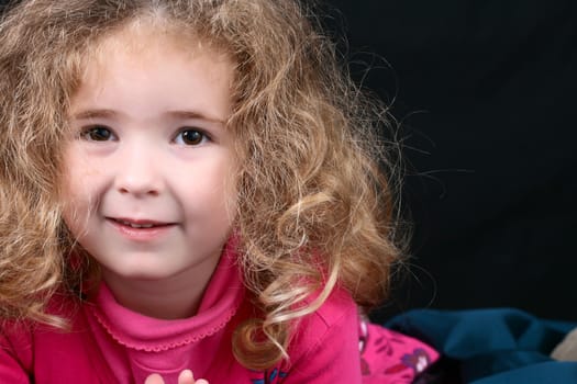 Little girl with curly hair wearing pink