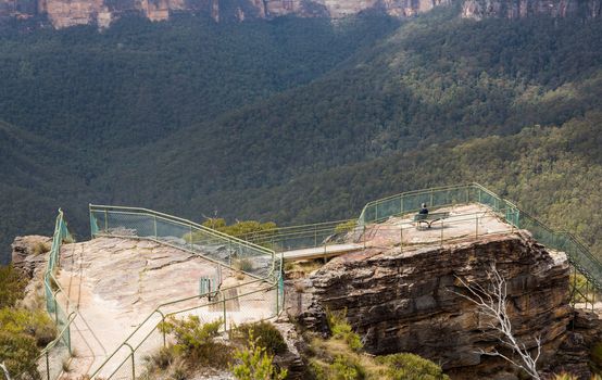Woman hiker approaching overlook  at Pulpit Rock overlooking the Grose Valley and majestic Blue Mountains NSW Australia