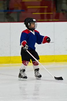 Child practicing ice skating and hockey