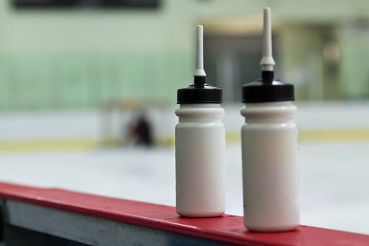 Water bottles on the boards in a hockey arena