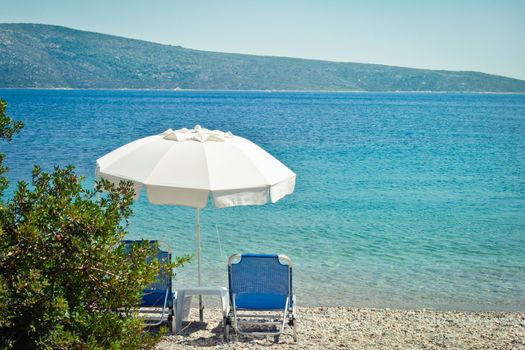 Sunloungers and a parasol on a beach in Greece