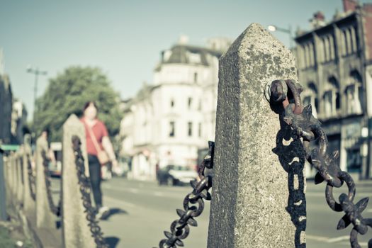 Vintage toned image of a city steet sith railings and shallow depth of field