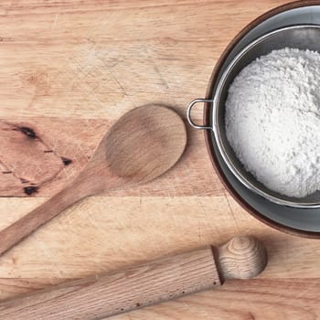 Baking items and flour on a wooden surface