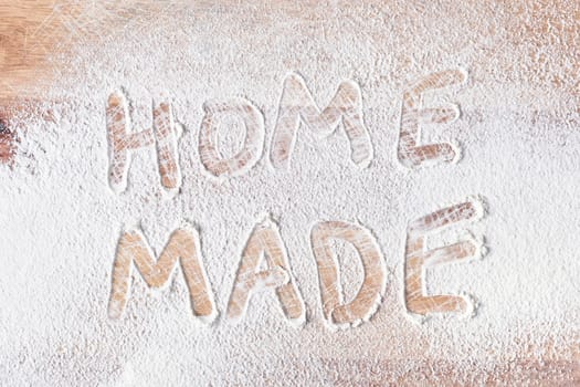 Home made written in flour on a wooden surface