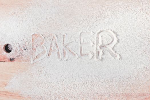 Baker written in flour on a wooden surface