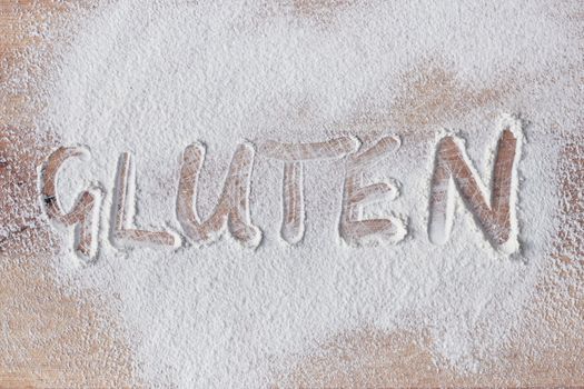 Gluten written in flour on a wooden surface