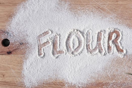 Flour written in flour on a wooden surface