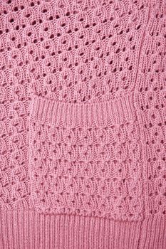 Close up of the pocket of a pink wool cardigan