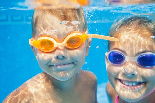 Close-up underwater portrait of the two cute smiling kids