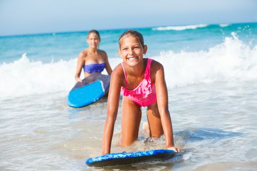 Summer vacation - Happy cute girl having fun with surfboard in the ocean