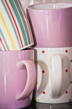 Stack of colorful mugs in a kitchen