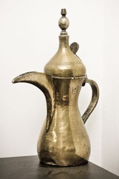 A traditional Omani brass coffee pot on a shelf