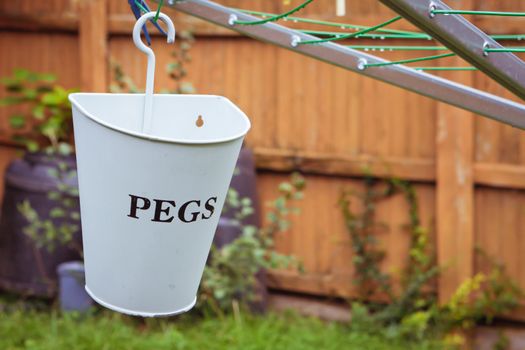 A metal peg holder hanging on a washing line