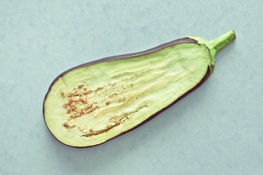 Slice of a fresh aubergine on a blue background