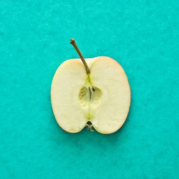 Slice of an apple on a green background