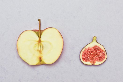 Slices of an apple and a fig on a lilac background