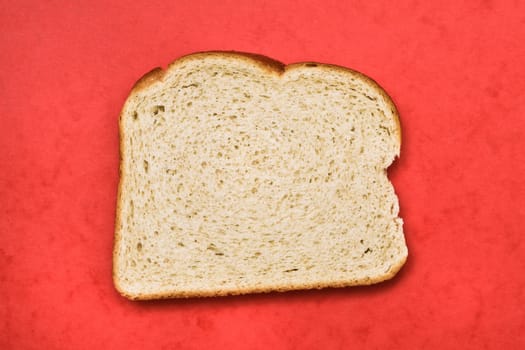 Slice of freshly baked white bread on a red background