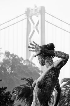 Statue with Bay Bridge in the background, Treasure Island, San Francisco, California, USA