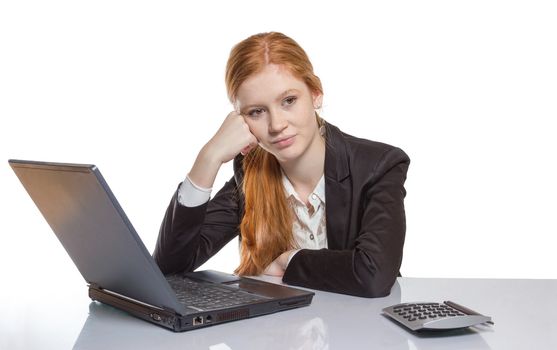 Young well dressed red haired Girl is sitting frustrated in front of the computer