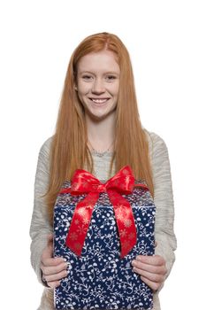 Young well dressed red haired Girl presents present with a big smile