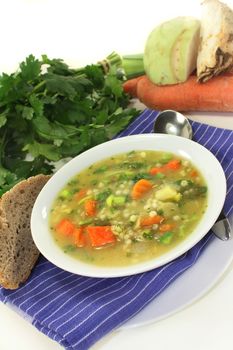 a bowl of colorful barley soup in front of white background